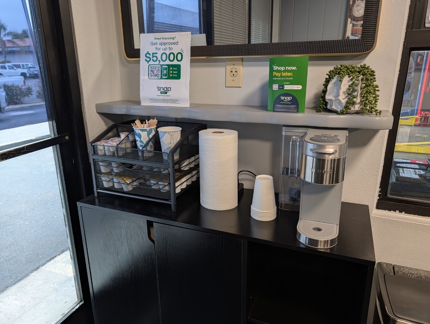 Coffee bar and Snap financing sign in the Perry's Auto Repair lobby