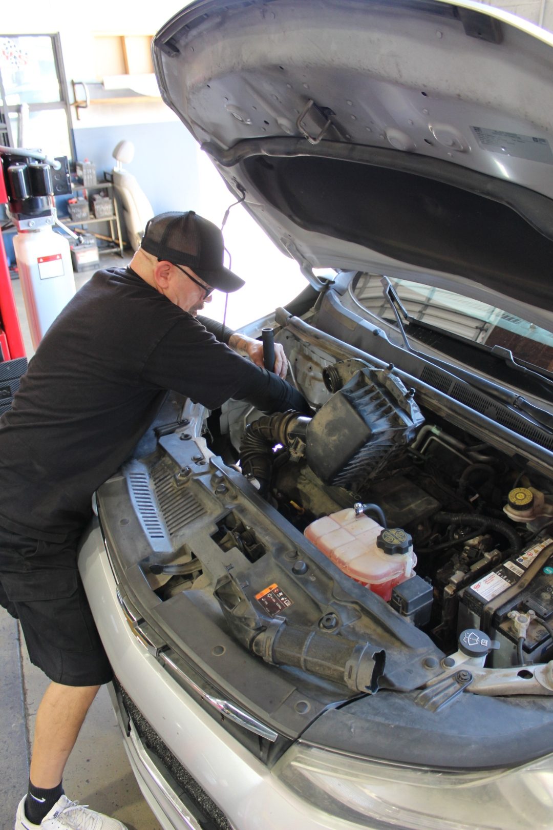 Master technician inspecting the air intake on a Chevrolet at Perry's Quality Auto