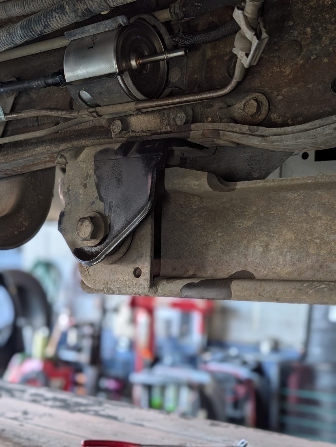 Newly installed fuel filter visible under a Ford during fuel system service